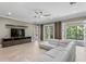 Living room featuring a comfortable gray sectional sofa, TV, neutral color palette, and access to the outdoor pool area at 47 Martinique Ave, Tampa, FL 33606