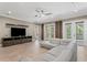 Bright living room featuring a comfortable gray sectional sofa, TV, neutral color palette, and access to the outside at 47 Martinique Ave, Tampa, FL 33606