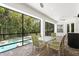 Relaxing screened patio with brick pavers, dining set and views of the beautiful pool and landscaping at 47 Martinique Ave, Tampa, FL 33606