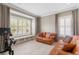 Bright sitting room with bay window, shutters, neutral tile flooring, and stylish sofas at 47 Martinique Ave, Tampa, FL 33606