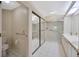 Accessible bathroom with shower, toilet, and sink, featuring grab bars and sliding glass doors at 5245 Lochmead Ter, Zephyrhills, FL 33541