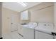 Bright laundry room features a washing machine and dryer plus built in cabinets and sink at 5245 Lochmead Ter, Zephyrhills, FL 33541
