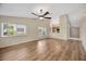 Open-concept living room with wood flooring, bright windows, and seamless flow into the kitchen area at 5245 Lochmead Ter, Zephyrhills, FL 33541
