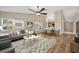 Bright living room with large windows, modern decor, and an open floor plan leading to dining area at 5245 Lochmead Ter, Zephyrhills, FL 33541