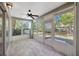 The sunroom features sliding windows, a ceiling fan and tiled flooring at 5245 Lochmead Ter, Zephyrhills, FL 33541