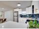 Stylish kitchen boasts white cabinetry, stainless steel appliances, dark backsplash, and a bright and airy design at 5444 70Th N Ln, St Petersburg, FL 33709