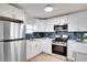 Modern kitchen featuring stainless steel appliances, white cabinets with gold hardware, and ample counter space at 5444 70Th N Ln, St Petersburg, FL 33709