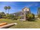 Rear exterior of home showing a screened-in patio overlooking lush green grass and tropical plants at 7345 Brightwaters Ct, New Port Richey, FL 34652