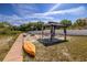 Backyard featuring a shady gazebo, fire pit, and dock on a tranquil lake at 7345 Brightwaters Ct, New Port Richey, FL 34652