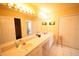 Bright bathroom featuring a long vanity with dual sinks and Hollywood lights at 7345 Brightwaters Ct, New Port Richey, FL 34652