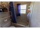 Functional bathroom featuring a bathtub with shower, window for ventilation, and storage shelves at 7345 Brightwaters Ct, New Port Richey, FL 34652