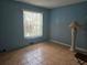 Empty bedroom with tile floors, natural light, and soothing blue walls creates a relaxing atmosphere at 7345 Brightwaters Ct, New Port Richey, FL 34652