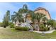 Attractive home with a welcoming entrance, complemented by mature palm trees and lush landscaping at 7345 Brightwaters Ct, New Port Richey, FL 34652