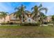 Charming exterior view of a two-story home with well-manicured landscaping and mature palm trees at 7345 Brightwaters Ct, New Port Richey, FL 34652