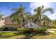 Two-story home featuring a well-manicured lawn and decorative palm trees at 7345 Brightwaters Ct, New Port Richey, FL 34652