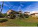 Rear of home showing a screened-in patio overlooking the yard with mature landscaping at 7345 Brightwaters Ct, New Port Richey, FL 34652