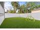 Beautiful backyard featuring a putting green, a climbing dome, artificial turf and privacy fence at 7417 S Morton St, Tampa, FL 33616