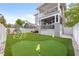 Large backyard with putting green, climbing dome, playset, patio, and artificial turf for low maintenance at 7417 S Morton St, Tampa, FL 33616