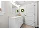 Bright bathroom featuring white vanity with granite counter, modern fixtures, and a decorative wreath at 7417 S Morton St, Tampa, FL 33616