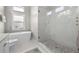 Bright bathroom featuring a soaking tub, walk-in shower with hexagon tile, and a window for natural light at 7417 S Morton St, Tampa, FL 33616