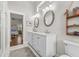Bright bathroom featuring double vanity with granite counters and decorative mirrors, and view to bedroom beyond at 7417 S Morton St, Tampa, FL 33616