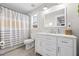 Bright bathroom with a vanity, shower with white and tan curtain, and window, offering a clean design at 7417 S Morton St, Tampa, FL 33616
