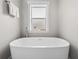 Modern bathtub next to window with picture frame on the windowsill at 7417 S Morton St, Tampa, FL 33616