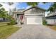Charming two-story home featuring a welcoming red front door, gray brick driveway and attached two-car garage at 7417 S Morton St, Tampa, FL 33616