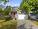 Charming two-story home featuring a welcoming red front door, gray brick driveway and attached two-car garage at 7417 S Morton St, Tampa, FL 33616