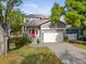 Charming two-story home featuring a welcoming red front door, gray brick driveway and attached two-car garage at 7417 S Morton St, Tampa, FL 33616