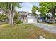 Charming two-story home featuring a welcoming red front door, gray brick driveway and attached two-car garage at 7417 S Morton St, Tampa, FL 33616