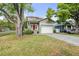 Charming two-story home featuring a welcoming red front door, gray brick driveway and attached two-car garage at 7417 S Morton St, Tampa, FL 33616