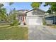 Charming home featuring well-manicured lawn, paved driveway, and inviting red front door at 7417 S Morton St, Tampa, FL 33616