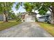 Charming two-story home featuring a red front door and a two-car garage with brick paved driveway at 7417 S Morton St, Tampa, FL 33616