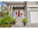 Inviting front porch with a red door, an American flag, and potted plants at 7417 S Morton St, Tampa, FL 33616