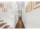 Hallway with hardwood floors, white walls, and decorative wall art at 7417 S Morton St, Tampa, FL 33616