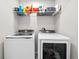 Bright laundry room featuring a Samsung washer and dryer and convenient overhead wire shelving at 7417 S Morton St, Tampa, FL 33616