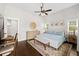 Bright main bedroom with decorative ceiling fan, desk area, and bench at the foot of the bed at 7417 S Morton St, Tampa, FL 33616