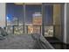 Bedroom showcasing a stunning night skyline view through large windows, and minimalist decor with comfortable bedding at 777 N Ashley Dr # 2610, Tampa, FL 33602