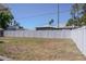 Backyard showing a white privacy fence, grass, and the exterior of the home at 7827 Crosier Ct, New Port Richey, FL 34653