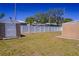 Backyard showcasing a white privacy fence, grass, and a storage shed at 7827 Crosier Ct, New Port Richey, FL 34653