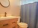 Cozy bathroom featuring a wooden vanity, modern faucet, and a shower with stylish curtain at 7827 Crosier Ct, New Port Richey, FL 34653