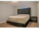Bedroom showcasing a large bed with a tufted headboard and a nightstand with mirrored drawers at 7827 Crosier Ct, New Port Richey, FL 34653