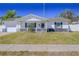 Inviting single-story home with a tidy front yard, white picket fence, and an attached one-car garage at 7827 Crosier Ct, New Port Richey, FL 34653