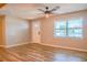 Bright living room featuring hardwood floors, a ceiling fan, and a large window providing ample natural light at 7827 Crosier Ct, New Port Richey, FL 34653