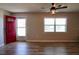 Open-concept living room with bright red door and modern ceiling fan at 7827 Crosier Ct, New Port Richey, FL 34653