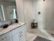 Bright bathroom with white marble tile, glass shower, and pebble floor at 7912 Causeway S Blvd, St Petersburg, FL 33707