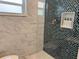 Modern bathroom showcases glass tile shower with niche and sleek white marble at 7912 Causeway S Blvd, St Petersburg, FL 33707