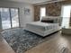 Bedroom with a stone accent wall, white linens and an ocean themed rug at 7912 Causeway S Blvd, St Petersburg, FL 33707