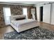 Bedroom with a stone accent wall, white linens and an ocean themed rug at 7912 Causeway S Blvd, St Petersburg, FL 33707
